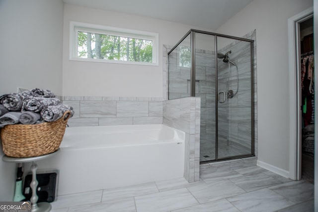 405 Adler Pt, Carrollton, GA 30117 - full bathroom featuring a garden tub, a stall shower, a spacious closet, and marble finish flooring