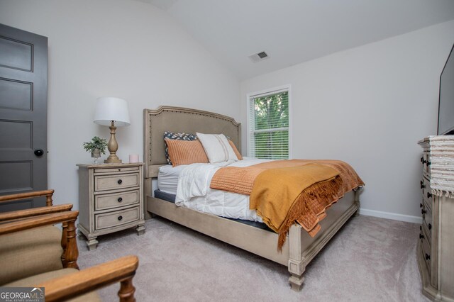 bedroom featuring light carpet, lofted ceiling, and baseboards