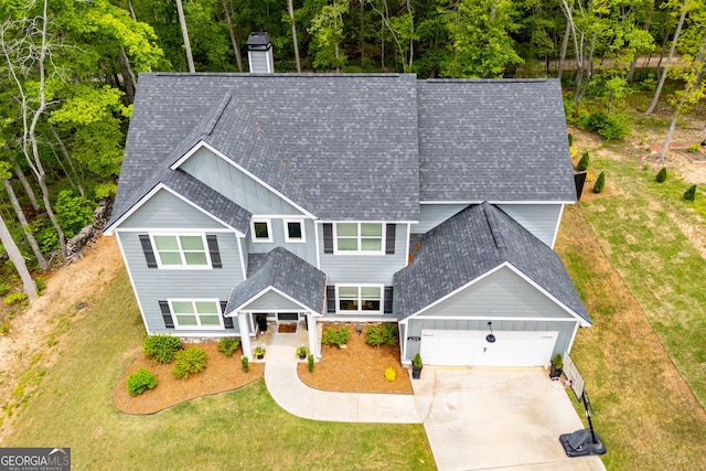 405 Adler Pt, Carrollton, GA 30117 - view of front facade with board and batten siding, roof with shingles, a chimney, an attached garage, and a front yard