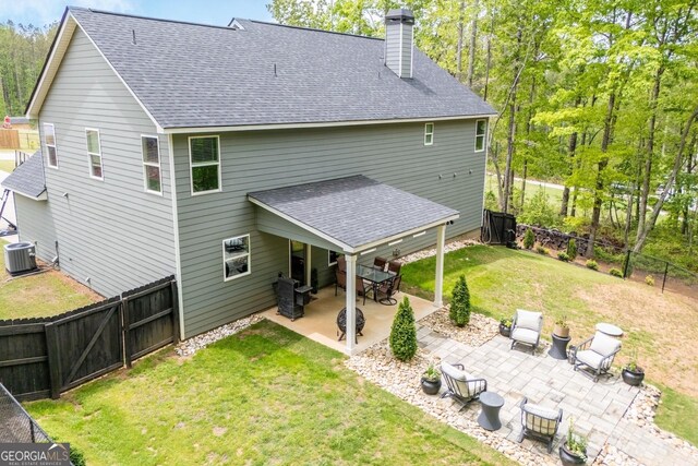 rear view of property with a shingled roof, central air condition unit, a chimney, a patio area, and a gate