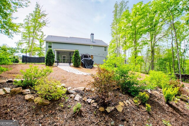 rear view of property featuring fence and a gate