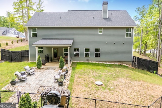 back of property with a gate, a patio, a chimney, and a shingled roof