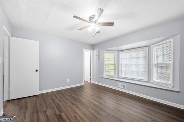 2352 S Hairston Rd, Decatur, GA 30035 - unfurnished bedroom with baseboards, dark wood-style flooring, a textured ceiling, and visible vents