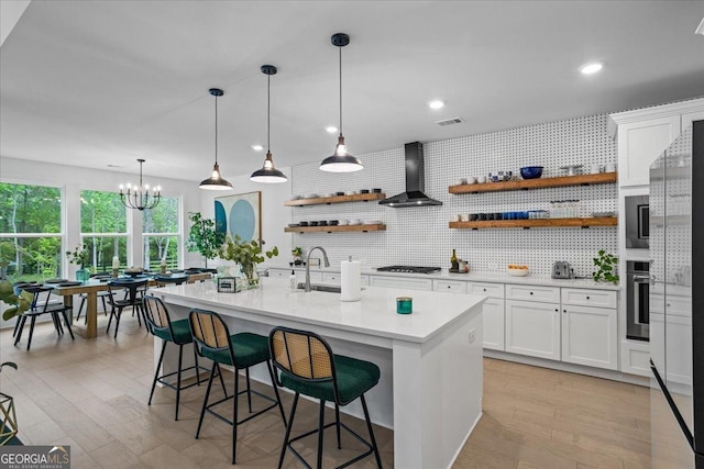 kitchen featuring white cabinets, open shelves, light countertops, wall chimney exhaust hood, and stainless steel oven