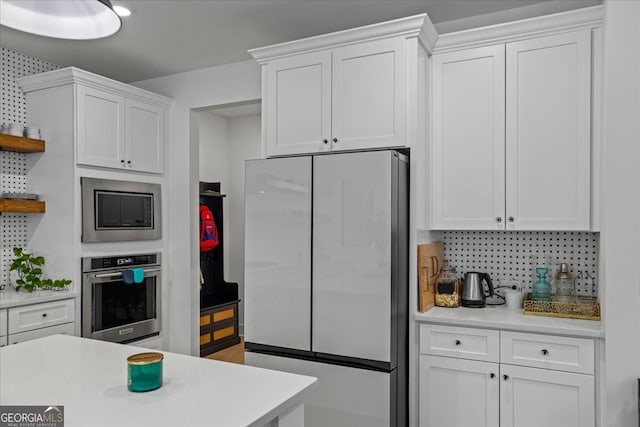 kitchen featuring open shelves, light countertops, white cabinets, and appliances with stainless steel finishes