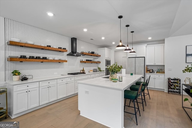 kitchen featuring white cabinets, backsplash, open shelves, a breakfast bar, and appliances with stainless steel finishes