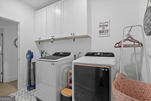 clothes washing area featuring independent washer and dryer and cabinet space