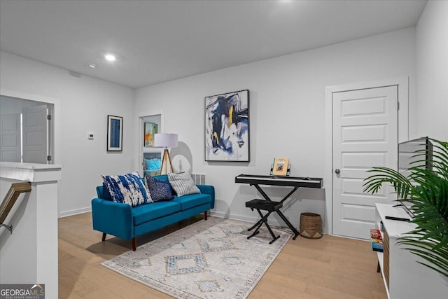 living area featuring baseboards, wood finished floors, visible vents, and recessed lighting