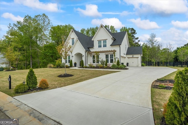 view of front of home featuring roof with shingles, concrete driveway, fence, an attached garage, and a front yard