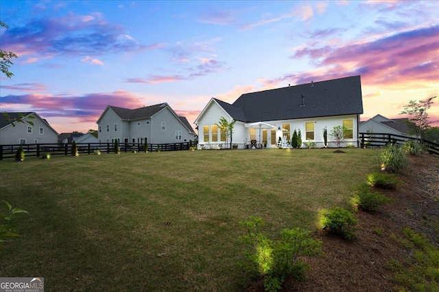 back of house with a lawn and a fenced backyard