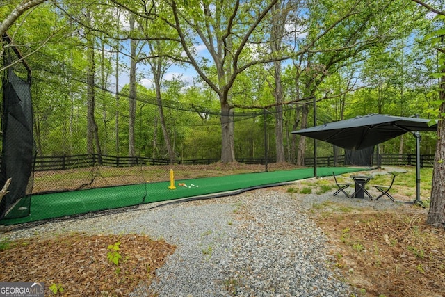 view of property's community featuring fence and a detached carport
