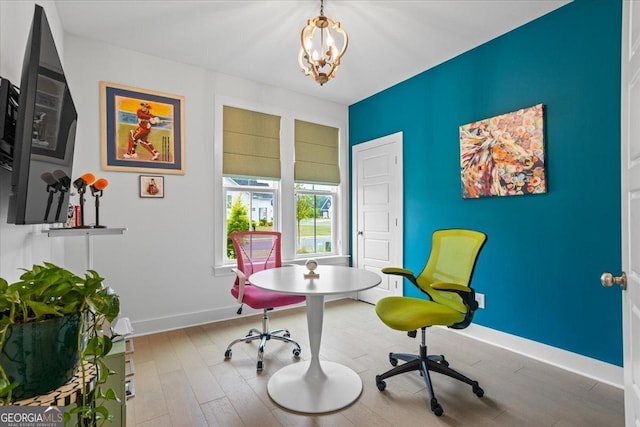 dining space featuring baseboards, wood finished floors, and an inviting chandelier
