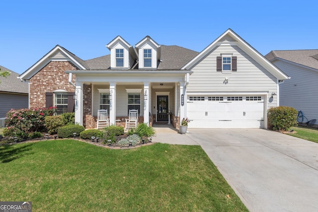 view of front of home with covered porch, a garage, brick siding, a front lawn, and concrete driveway