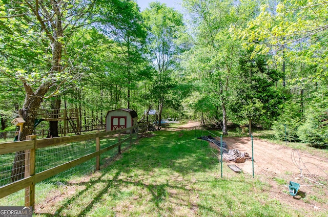 view of yard featuring fence, an outbuilding, and a storage unit