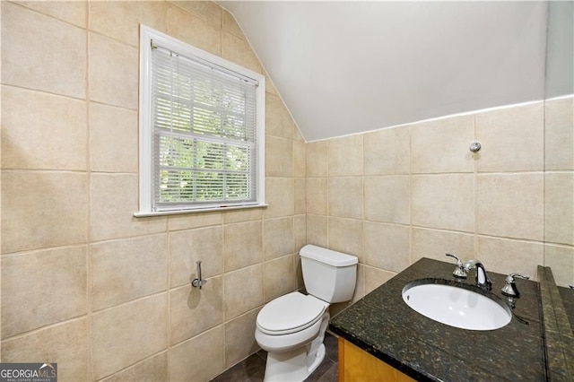5655 Errol Pl NW, Atlanta, GA 30327 - bathroom featuring lofted ceiling, vanity, toilet, and tile walls