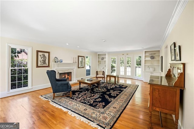 5655 Errol Pl NW, Atlanta, GA 30327 - living room featuring crown molding, light wood finished floors, built in features, and a wealth of natural light
