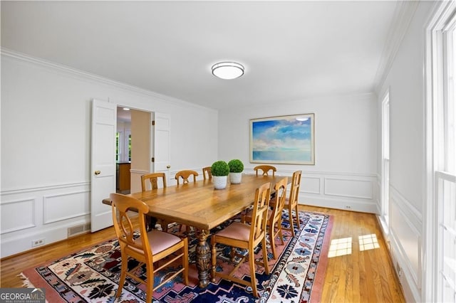 5655 Errol Pl NW, Atlanta, GA 30327 - dining area featuring visible vents, crown molding, a decorative wall, and light wood-style floors
