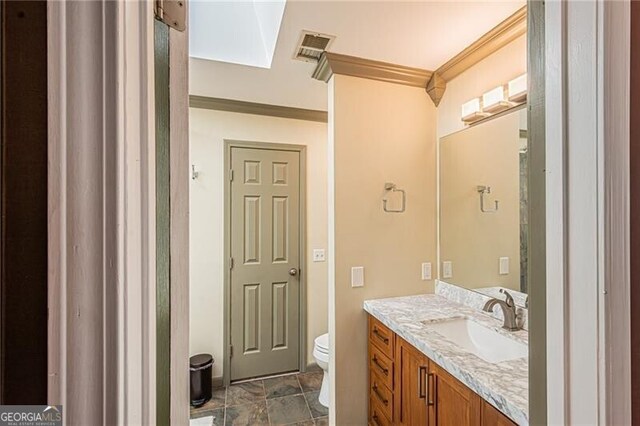 227 River Ridge Rd S, Dahlonega, GA 30533 - bathroom featuring toilet, visible vents, a skylight, vanity, and ornamental molding