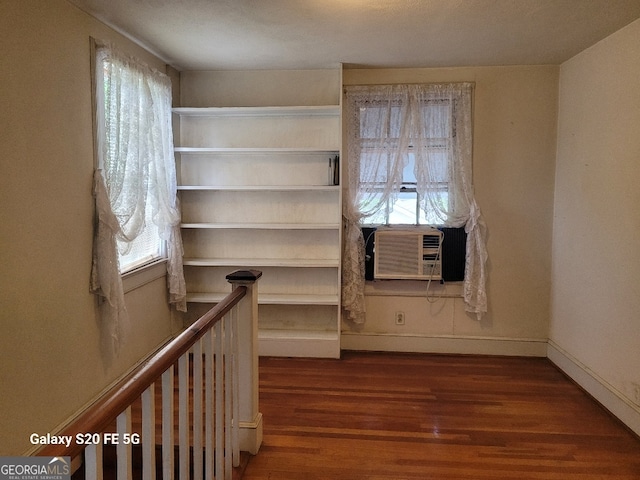 unfurnished room with baseboards, wood finished floors, and cooling unit