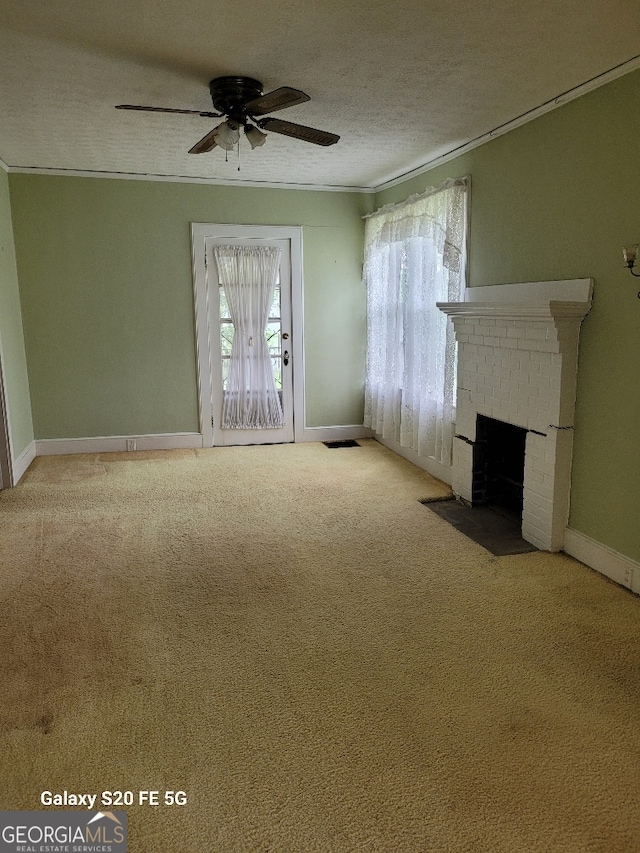 unfurnished living room featuring ornamental molding, ceiling fan, a healthy amount of sunlight, and carpet flooring