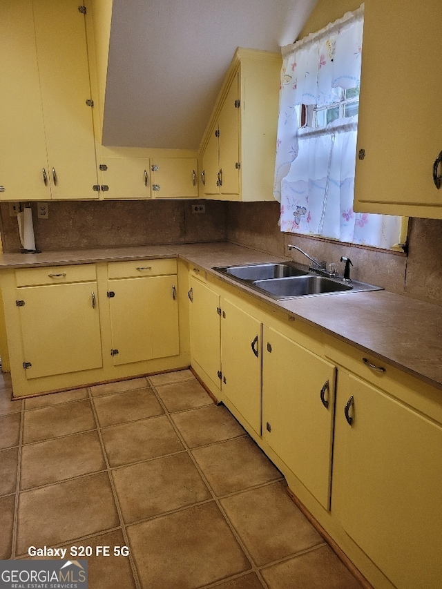 kitchen featuring a sink, light tile patterned floors, backsplash, and light countertops