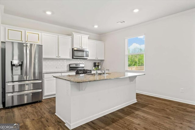 kitchen featuring appliances with stainless steel finishes, a sink, light stone counters, a center island with sink, and dark wood finished floors