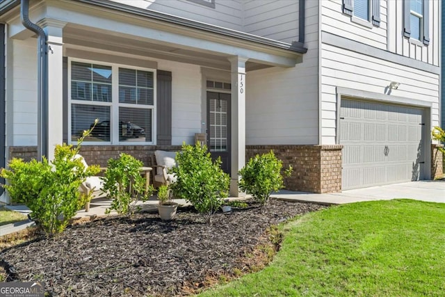 doorway to property featuring brick siding, an attached garage, a porch, and concrete driveway
