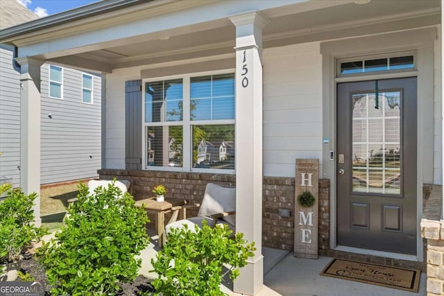 doorway to property with covered porch and stone siding