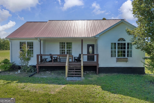 back of house featuring a lawn, metal roof, and a porch