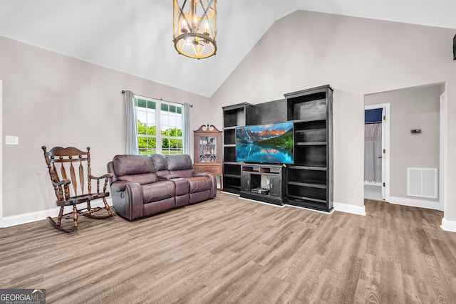 living room featuring visible vents, a chandelier, baseboards, wood finished floors, and high vaulted ceiling