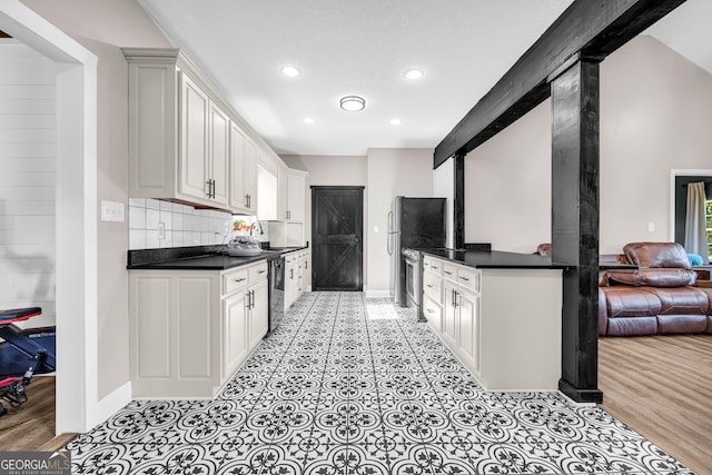 kitchen featuring open floor plan, dark countertops, dishwasher, and recessed lighting