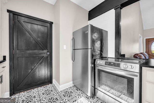 kitchen with dark countertops, stainless steel appliances, white cabinets, and baseboards