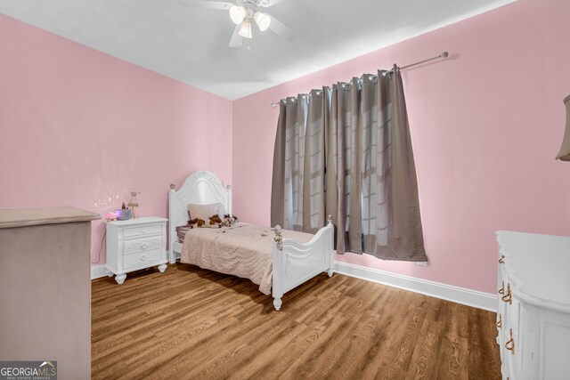 bedroom featuring baseboards, wood finished floors, and ceiling fan