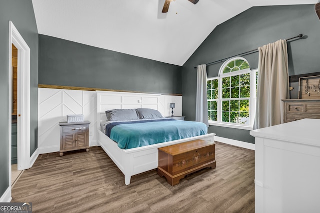 bedroom with ceiling fan, wood finished floors, lofted ceiling, and baseboards