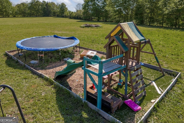 view of playground featuring a trampoline and a yard