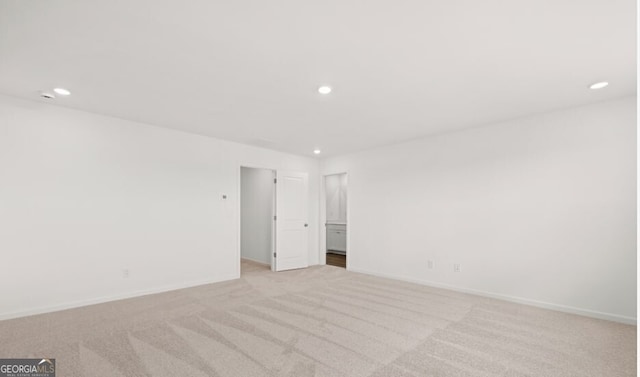 empty room featuring recessed lighting, baseboards, and light colored carpet
