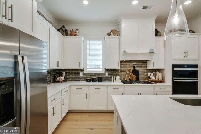 kitchen featuring a sink, light wood-type flooring, visible vents, white cabinetry, and appliances with stainless steel finishes