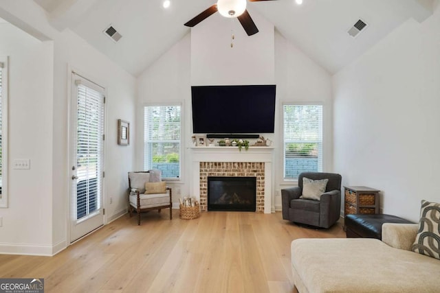 living area with visible vents, high vaulted ceiling, light wood-style floors, and ceiling fan