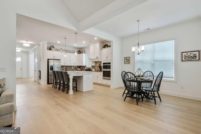 dining area with a chandelier, light wood finished floors, baseboards, visible vents, and recessed lighting