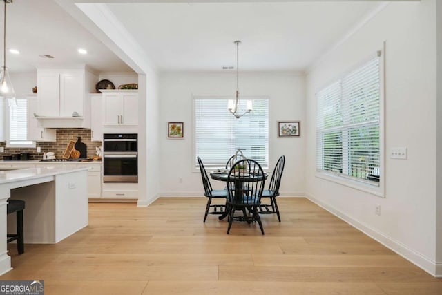 dining room featuring baseboards, recessed lighting, a notable chandelier, light wood-style floors, and crown molding