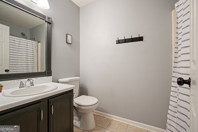 bathroom featuring baseboards, vanity, tile patterned flooring, and toilet