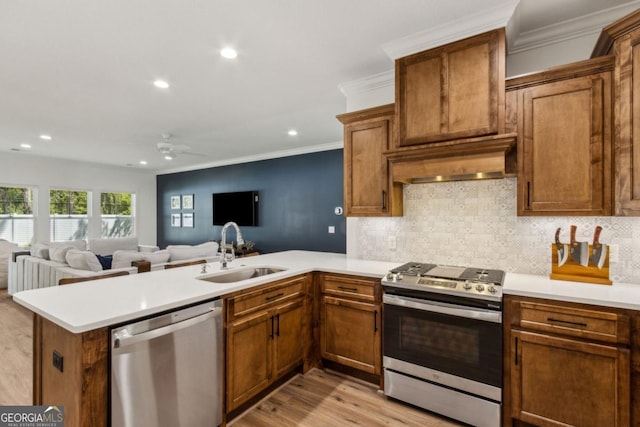 166 Verano St, Kingsland, GA 31548 - kitchen with stainless steel appliances, exhaust hood, a peninsula, a ceiling fan, and ornamental molding