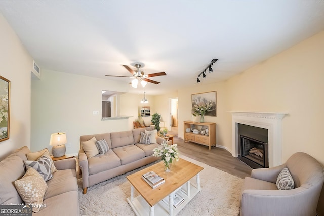 1206 Canyon Point Cir, Roswell, GA 30076 - living area with visible vents, a ceiling fan, a glass covered fireplace, and light wood-style floors