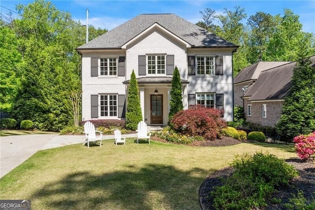 view of front of house with brick siding and a front lawn