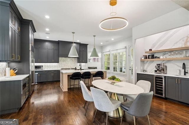 dining space with recessed lighting, dark wood finished floors, beverage cooler, and indoor wet bar