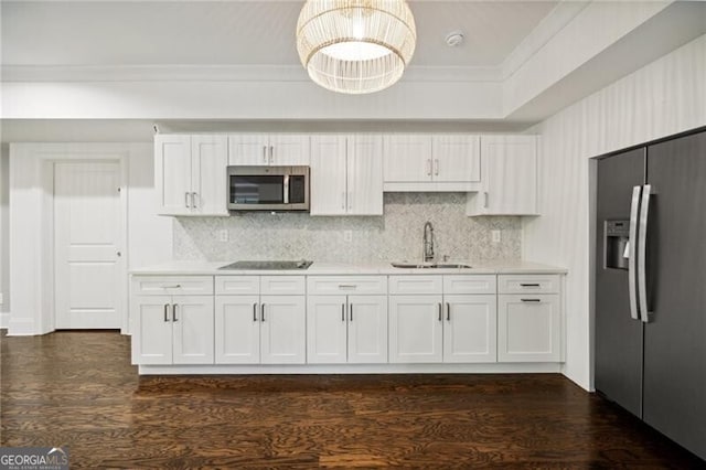 kitchen with stainless steel appliances, a sink, white cabinetry, crown molding, and light countertops