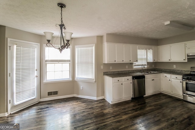 6024 S Deshon Ct, Lithonia, GA 30058 - kitchen featuring appliances with stainless steel finishes, a textured ceiling, dark countertops, a chandelier, and white cabinets