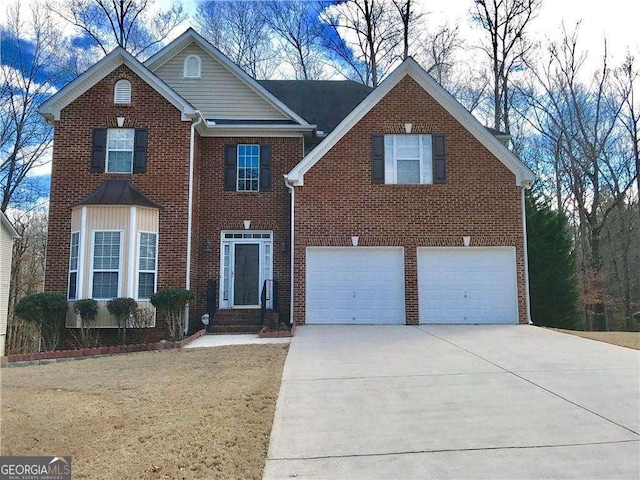 traditional-style home featuring an attached garage, a front yard, driveway, and brick siding