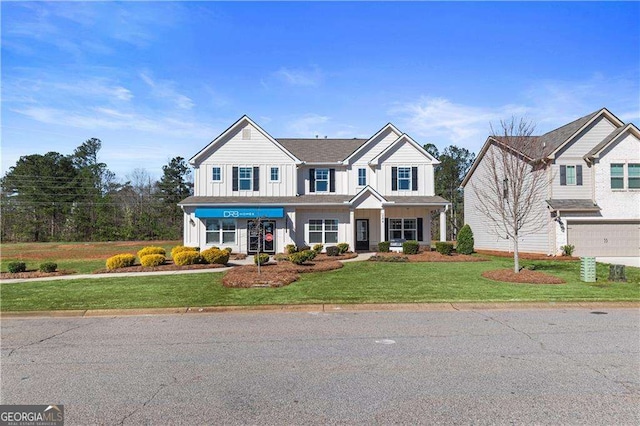 view of front of home with board and batten siding, a front yard, and a garage