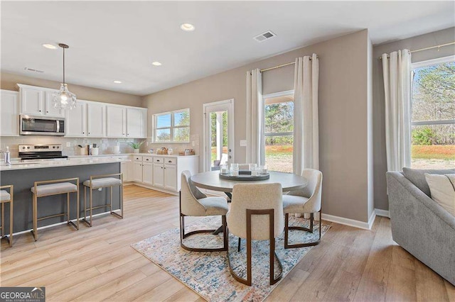 dining room featuring light wood-type flooring, baseboards, visible vents, and recessed lighting